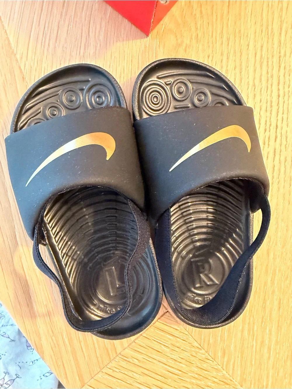 Nike Kids Black Slides with Gold Swoosh and Heel Strap